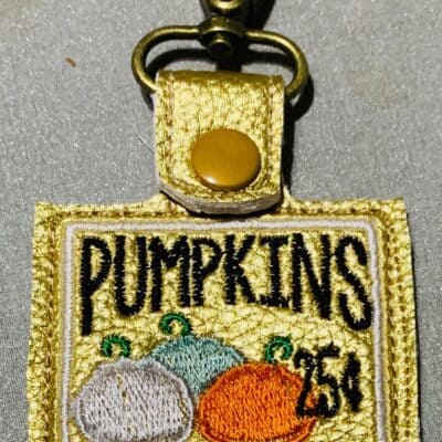 Vintage embroidered Pumpkins patch keychain with metal clasp for gardening or fall decor.