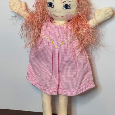 Handmade fabric doll with pink gingham dress and pink yarn hair.