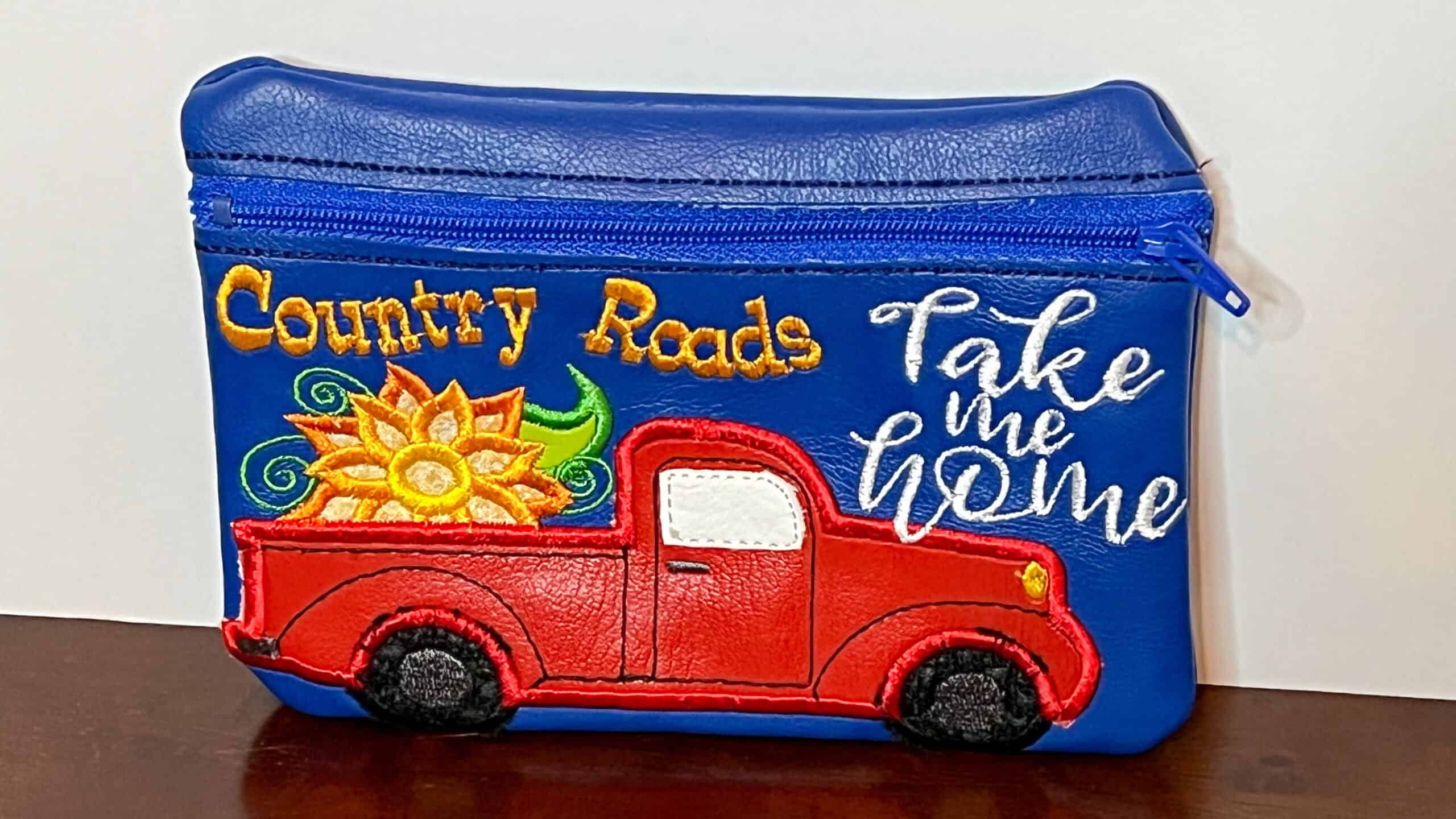 Country Roads embroidered zippered pouch, take me home, vibrant red truck and sunflower design, perfect for travel and everyday use.