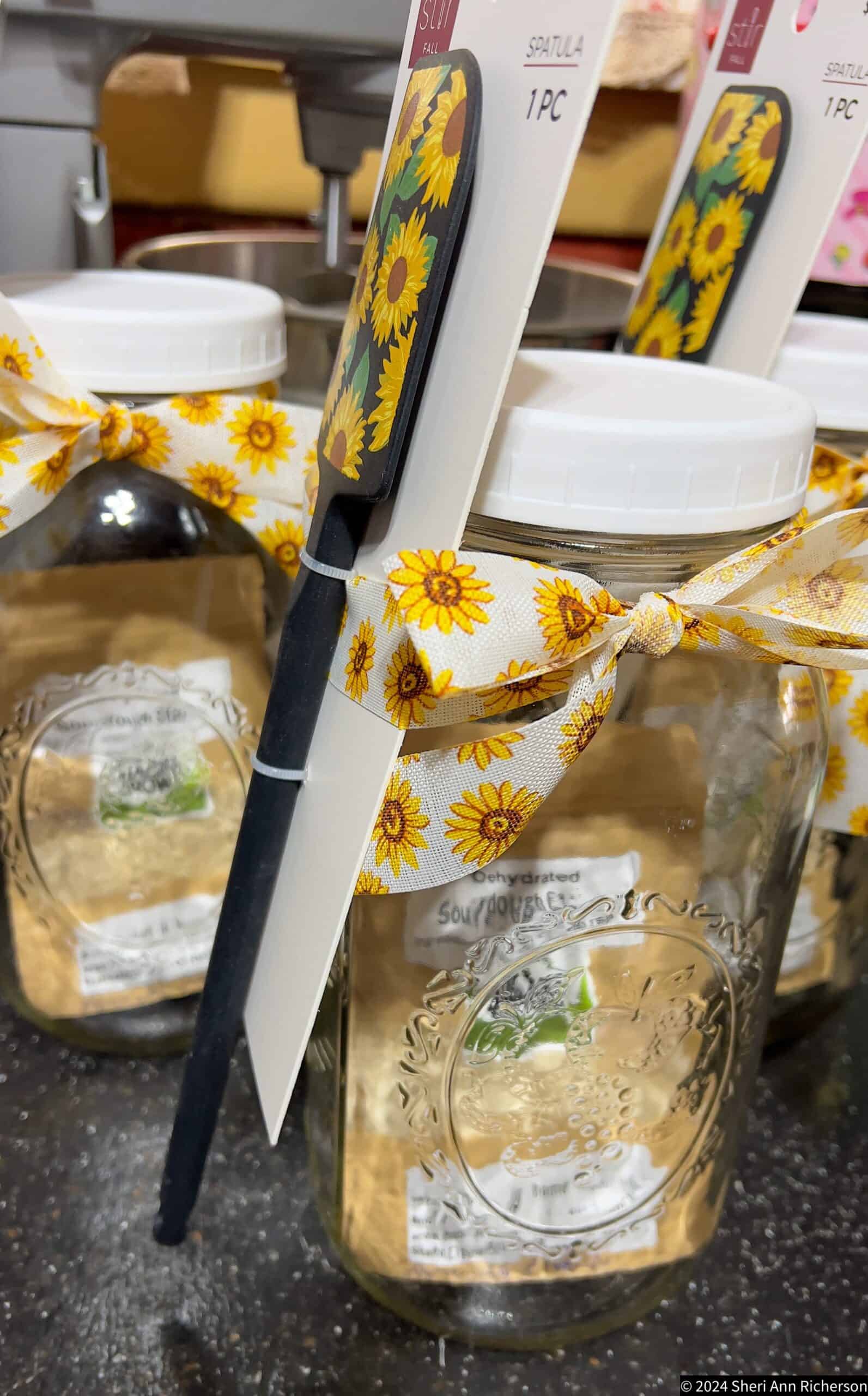 Sunflower-themed spatula and jars with sunflower ribbon, perfect for rustic kitchen decor and homesteading.
